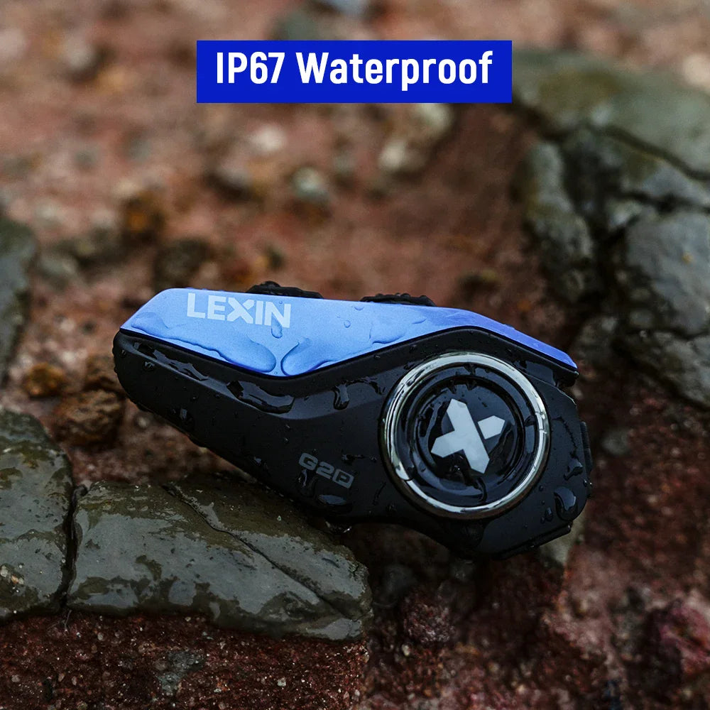 Waterproof motorcycle helmet intercom device resting on wet rocks.