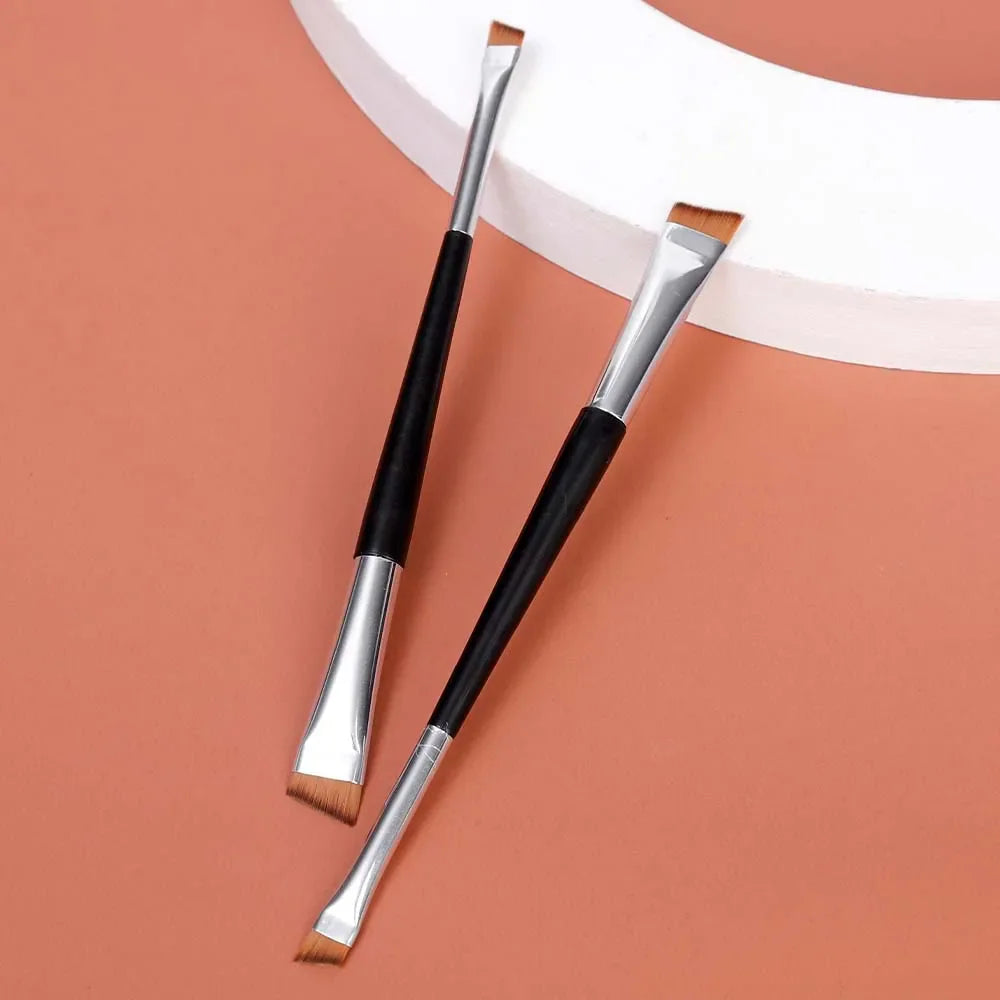 Two double-ended angled makeup brushes on a plain background
