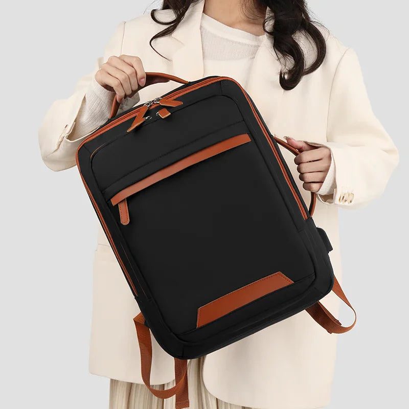 Person holding a black expandable laptop backpack by the handle