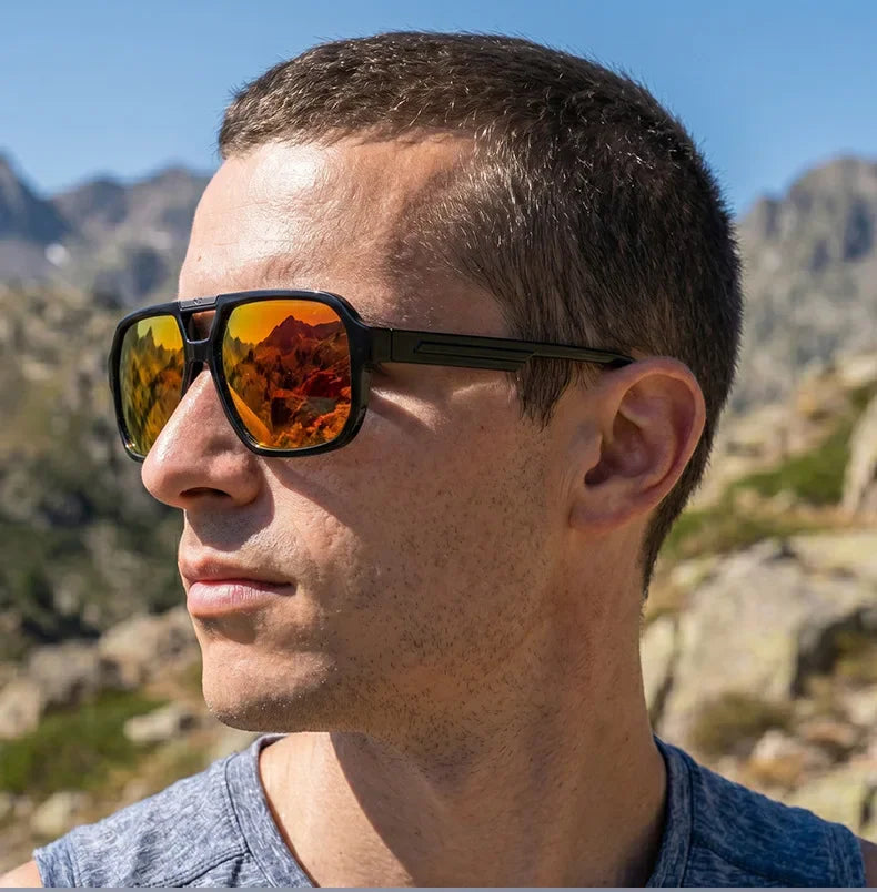 Man wearing polarized sunglasses with reflective orange lenses in a mountainous landscape