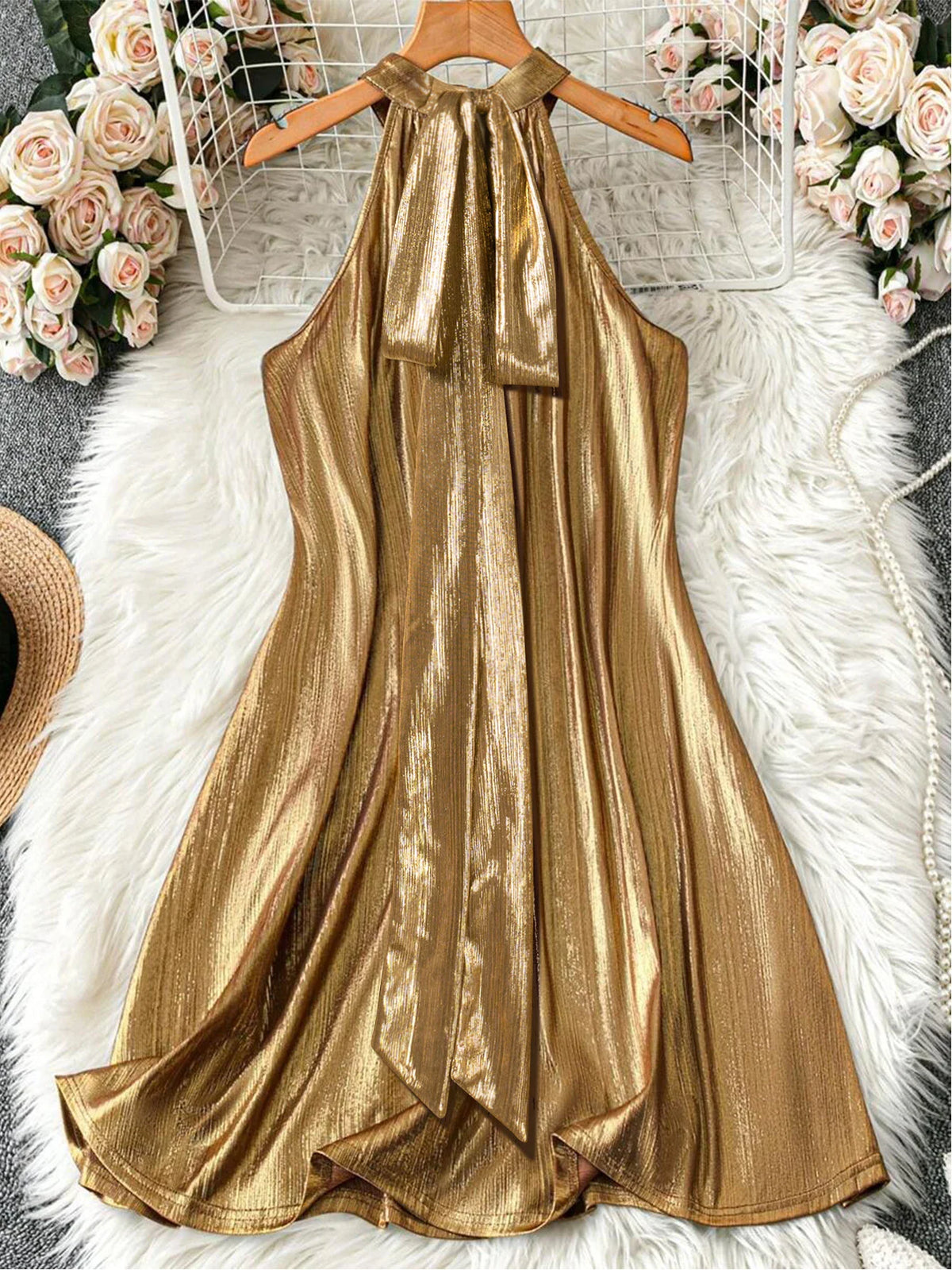 Metallic gold sleeveless halter mini dress on a hanger