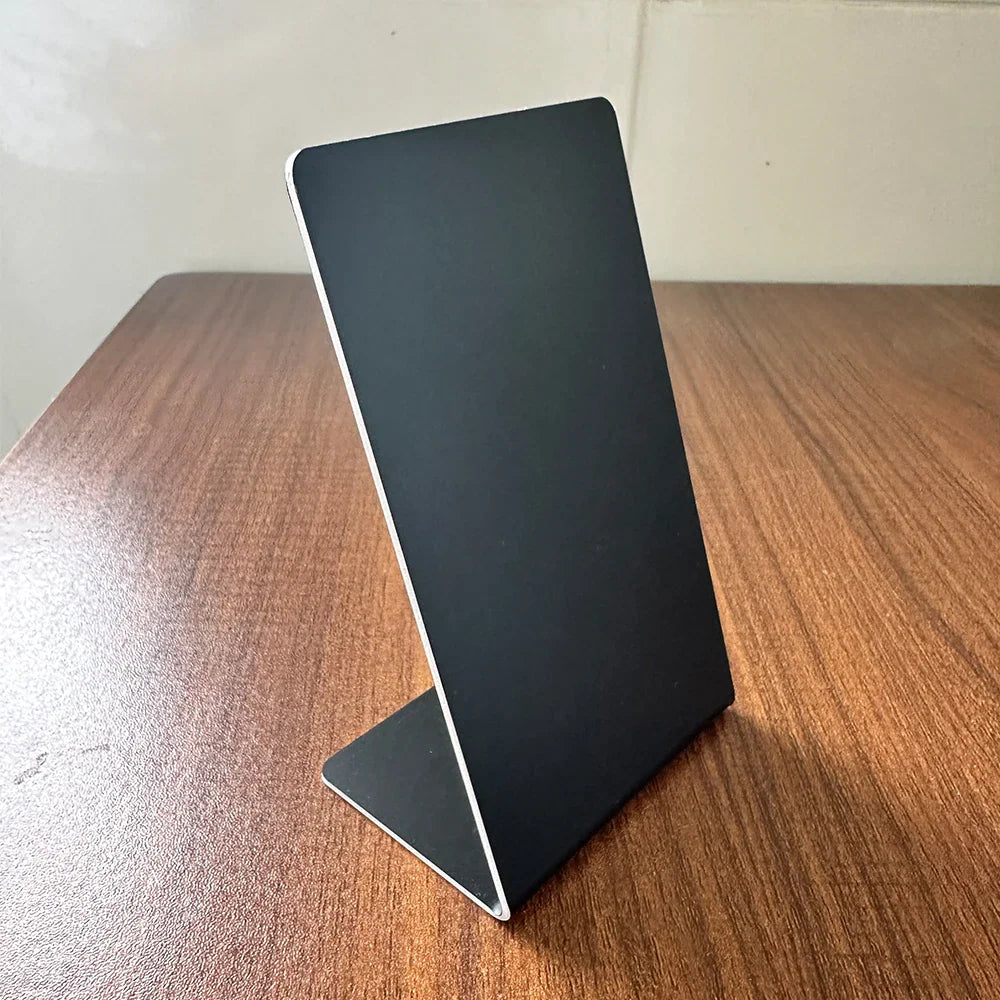 Plain black L-shaped plastic display stand for business on a wooden surface