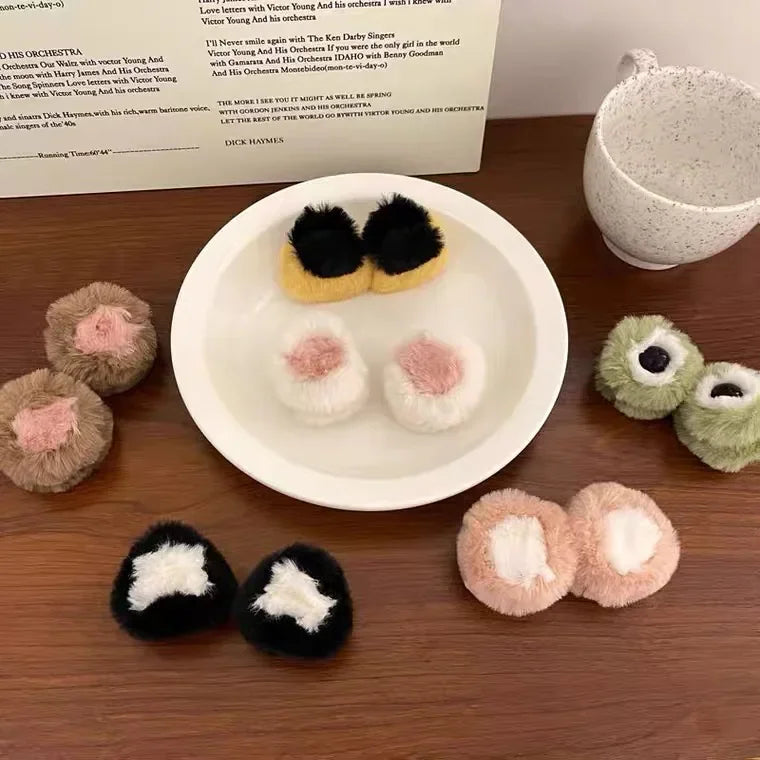 A collection of various plush animal ear hair clips on a white plate