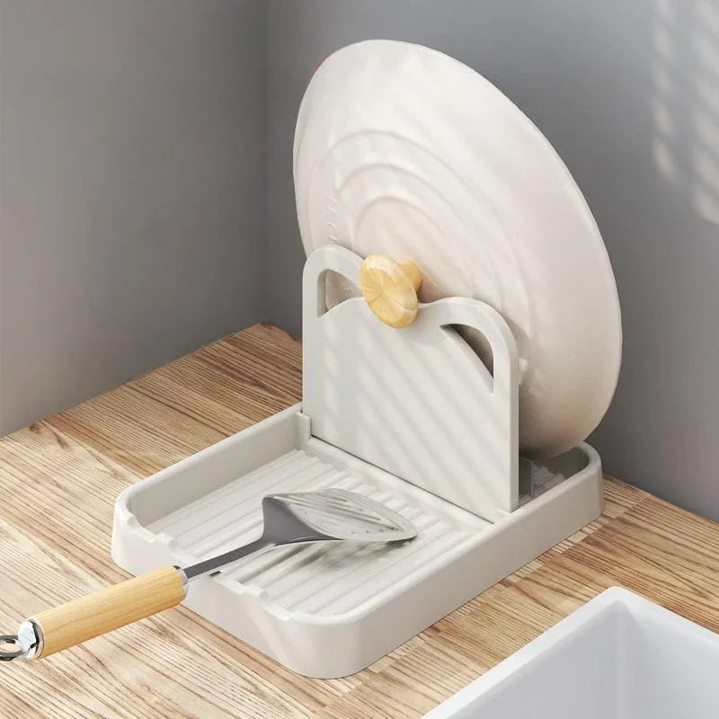 A beige kitchen utensil rest holding a pan lid and a spatula.