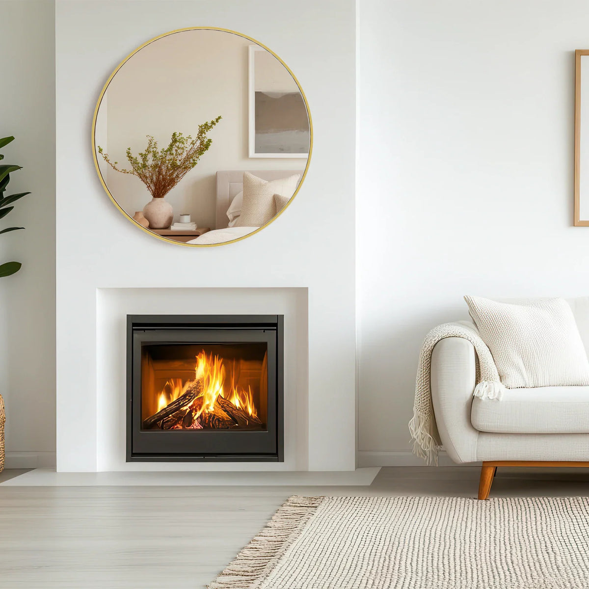 A round gold framed mirror hanging above a fireplace in a living room