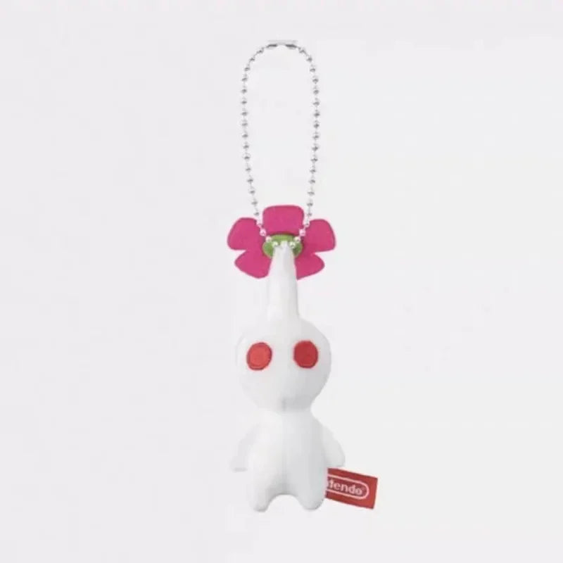 A small white plush doll keychain with a pink flower on its head