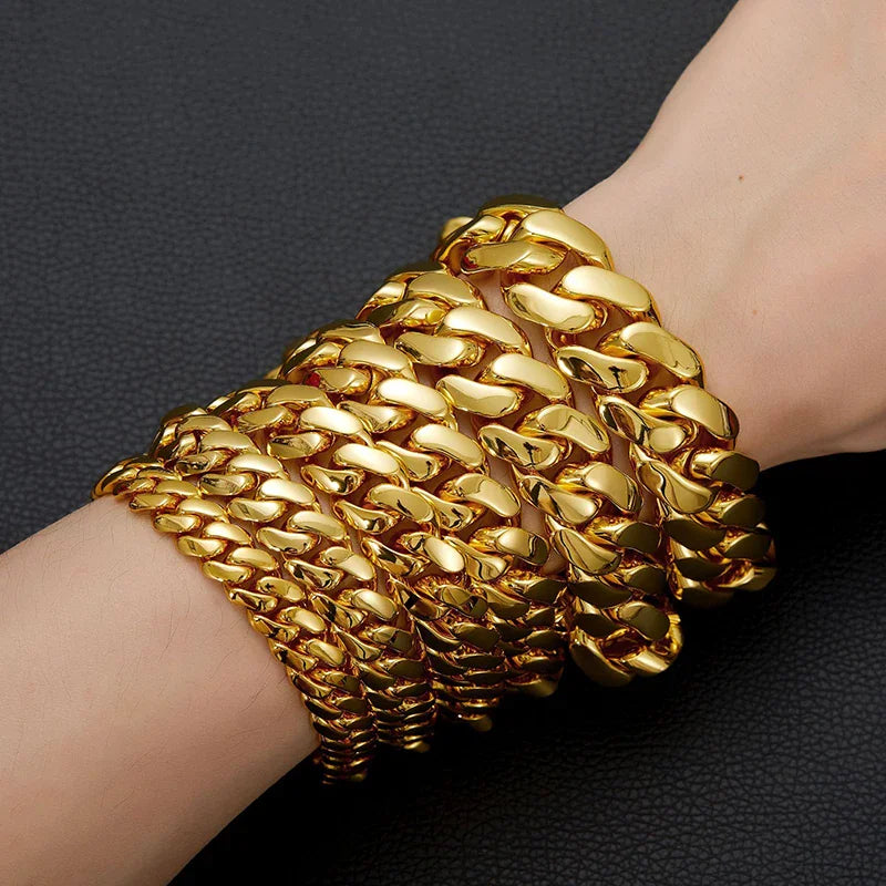 Stack of gold cuban link bracelets on a person's wrist