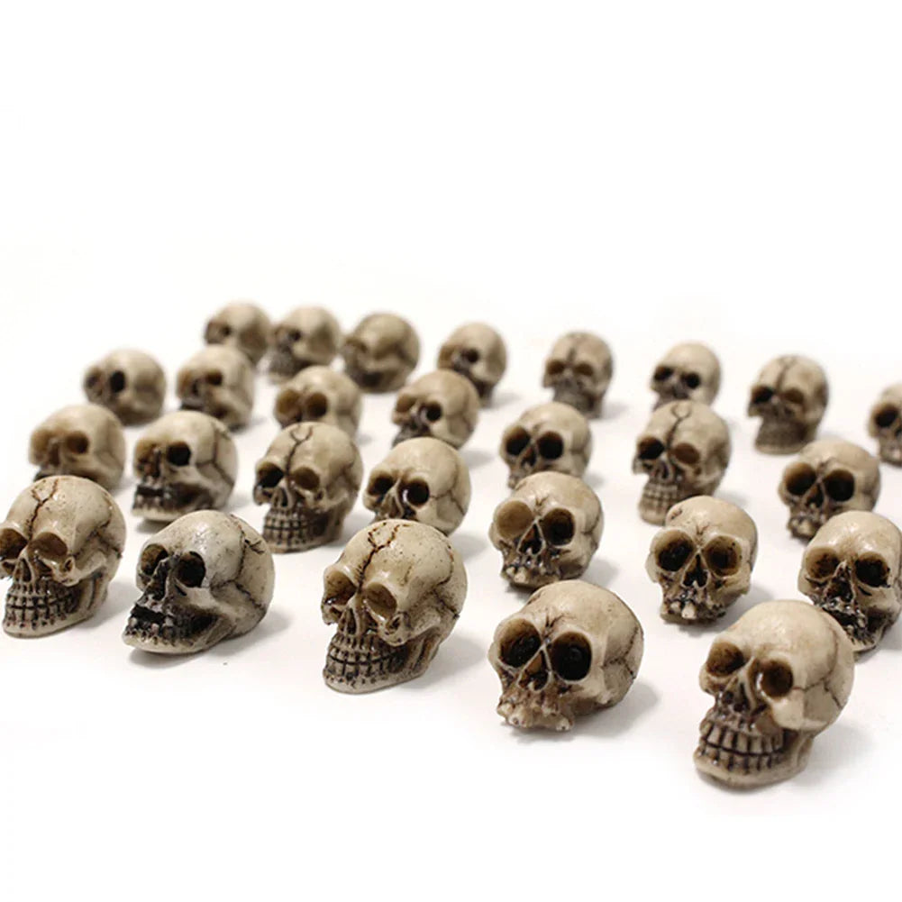 Set of miniature skull figurines on a white background