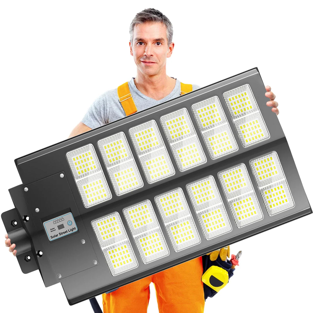 A man in work clothes holding a large solar LED street light.