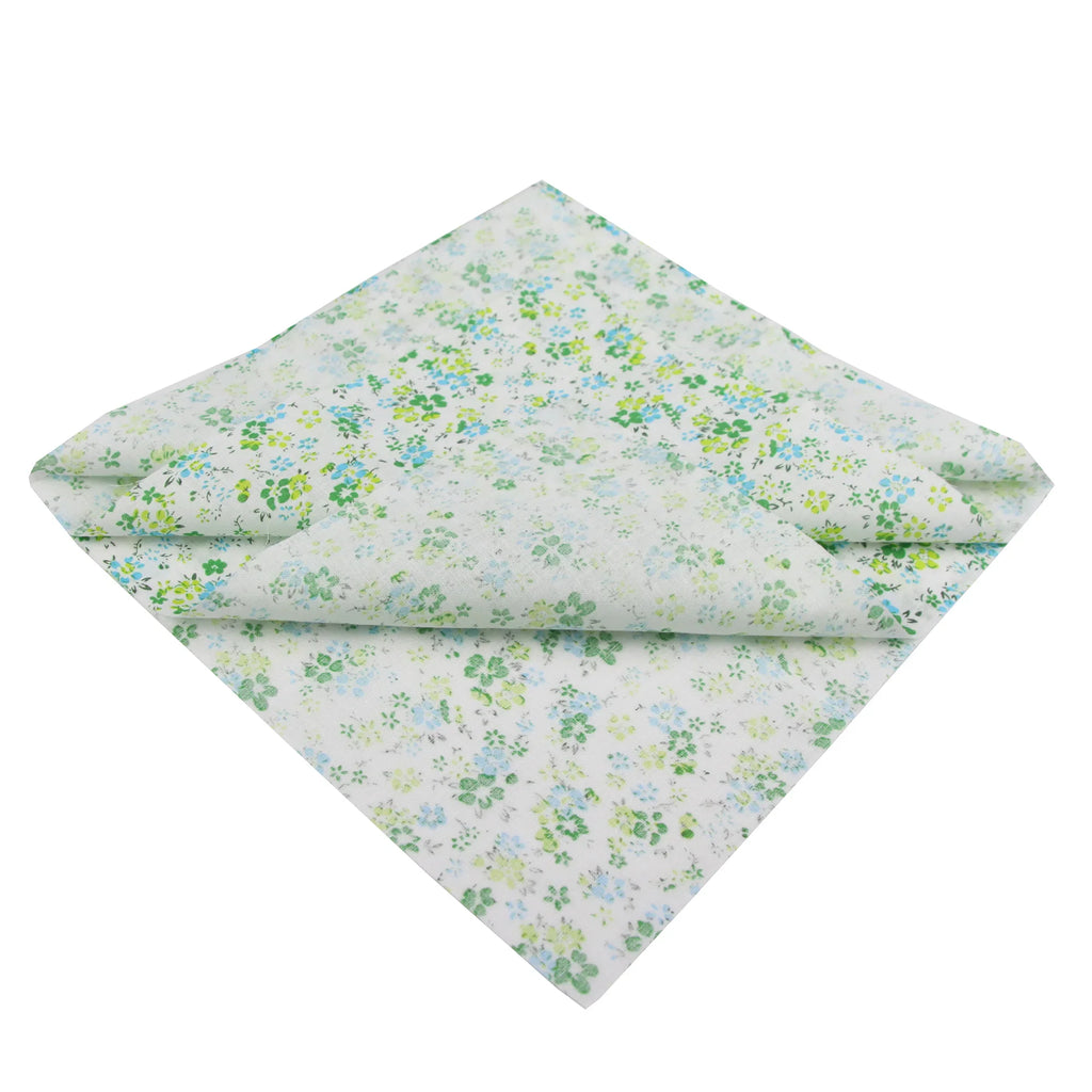 A folded square of white cotton fabric with a delicate blue and green floral pattern.