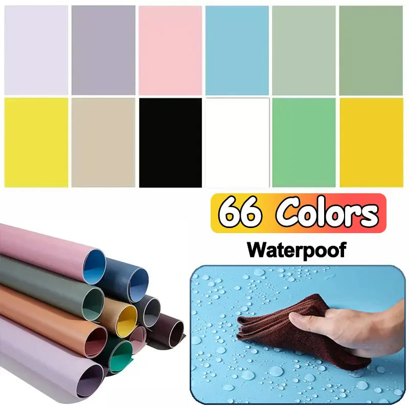 Collection of various solid color photography backdrop sheets displayed in rolls and being wiped clean