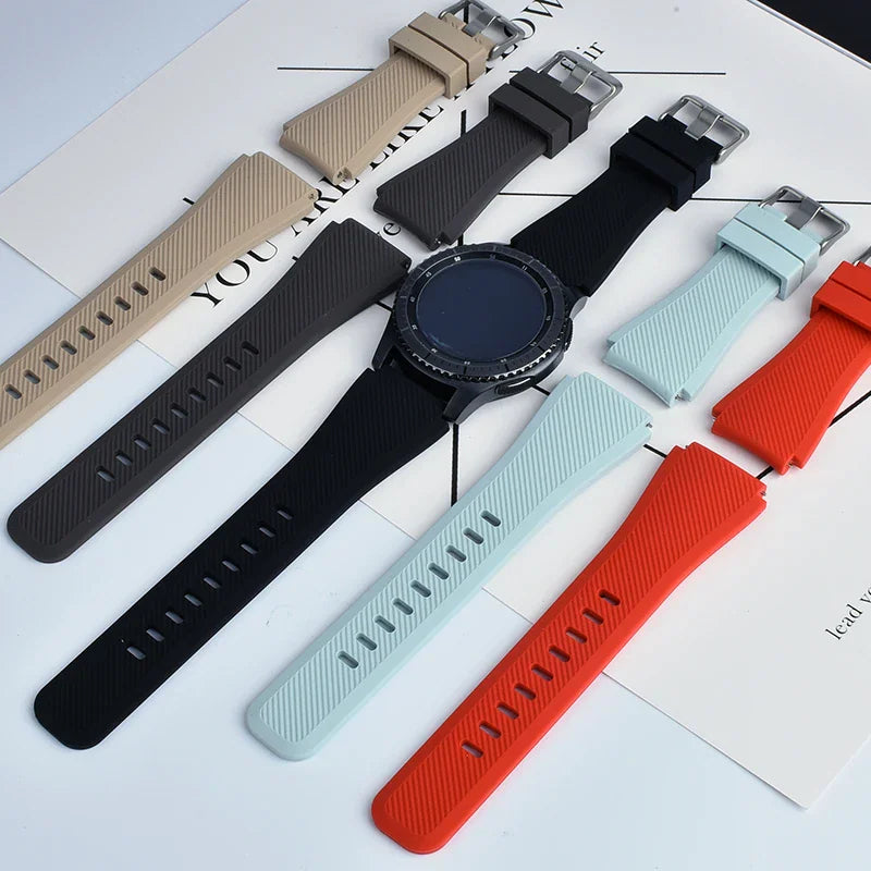 A collection of silicone smartwatch bands in various colors displayed with a smartwatch face.