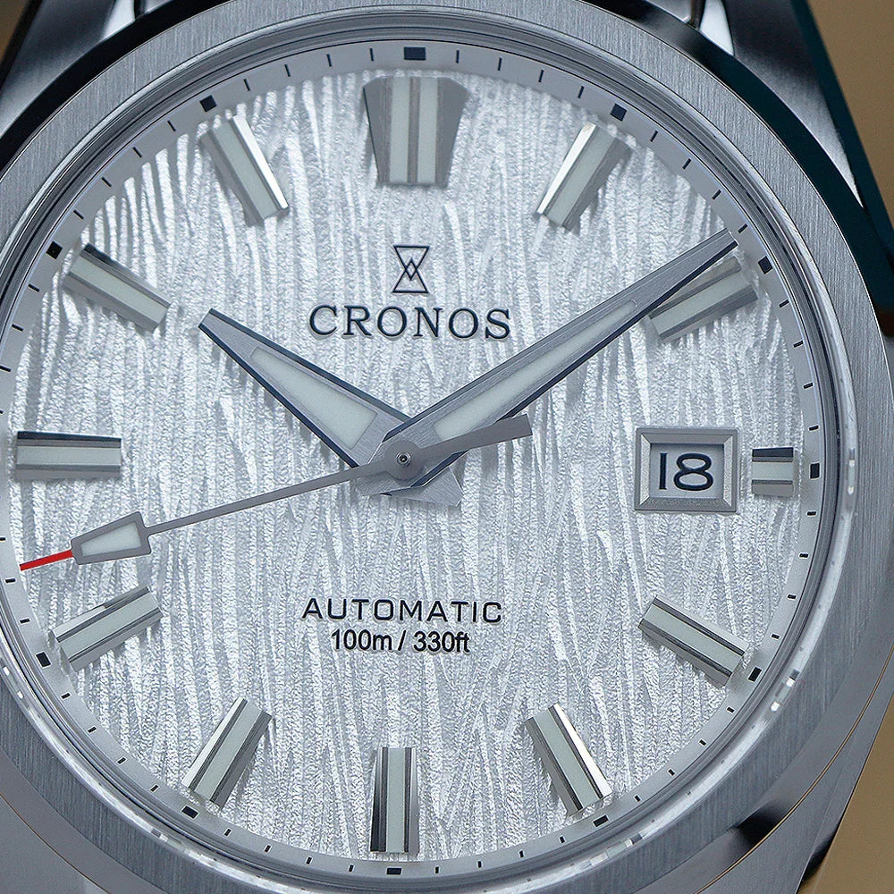 A close-up view of the dial of a men's automatic stainless steel wristwatch showing the birch-inspired white texture.