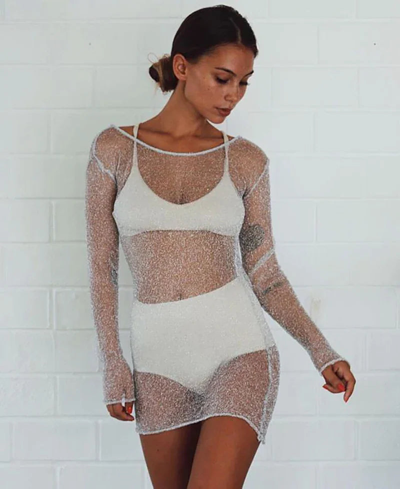 Woman wearing a silver metallic sheer mesh long-sleeved cover-up over a white bikini