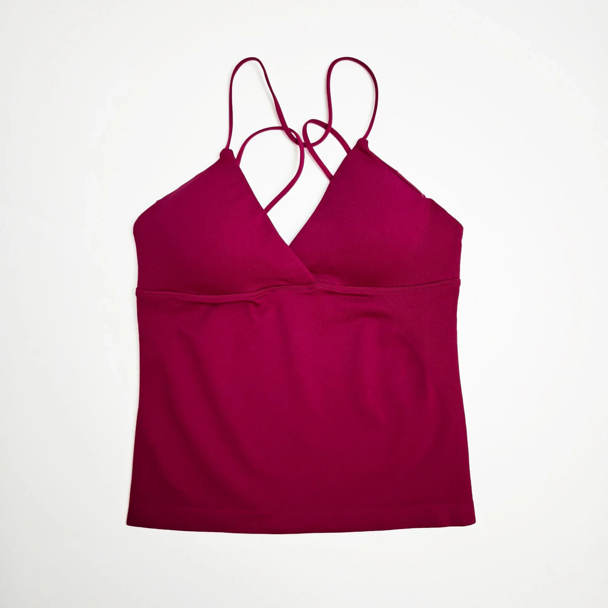 A sleeveless deep-v workout tank top in magenta with thin straps.