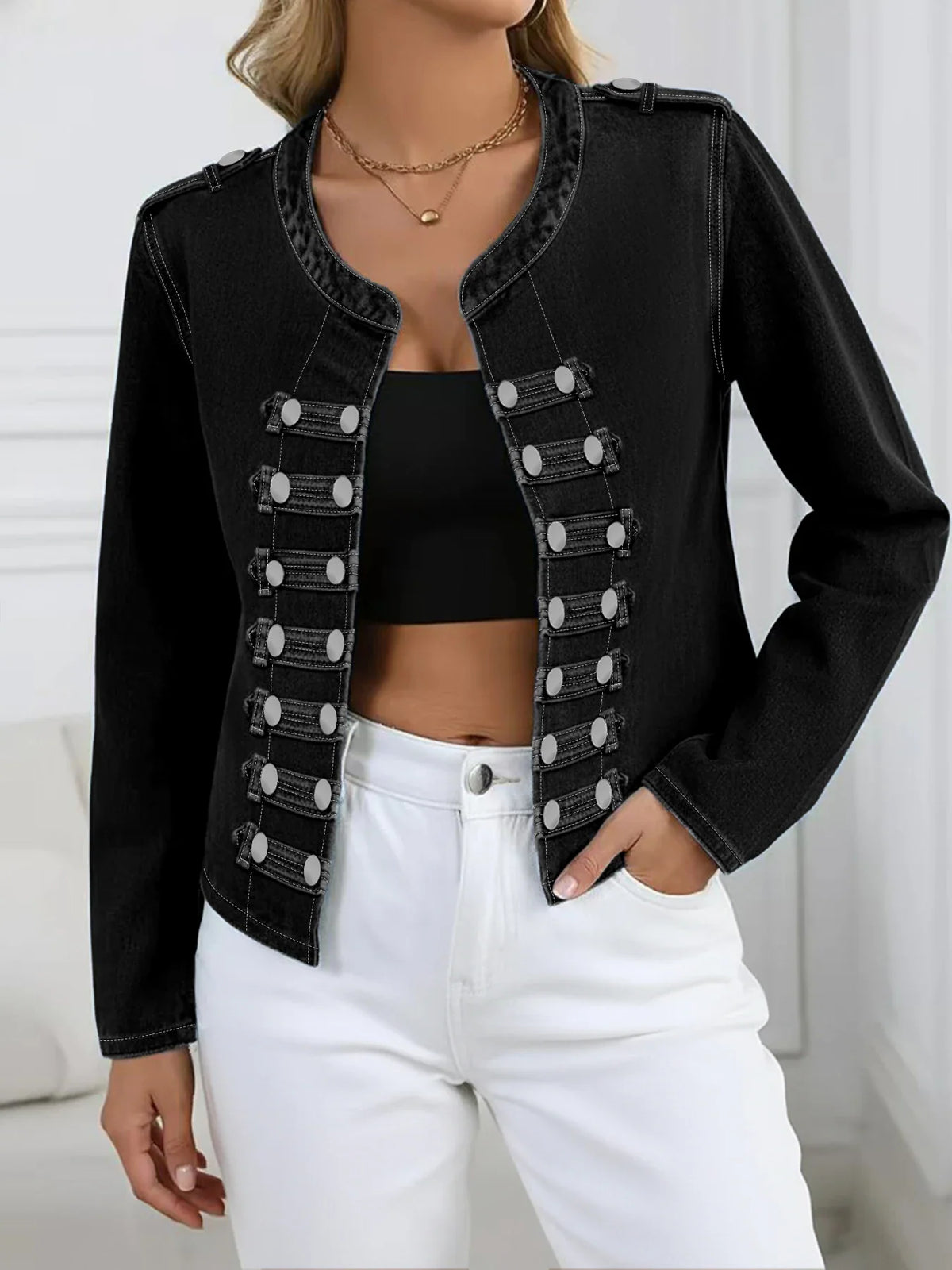 Woman wearing a black washed denim jacket with double-row button detailing and white jeans
