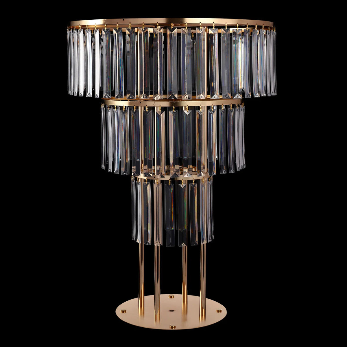 Three-tier gold metal wedding centerpiece stand with hanging crystal prisms isolated on a black background.