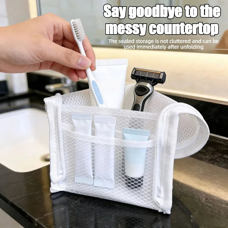 A white mesh standing toiletry bag filled with bathroom items on a vanity countertop.
