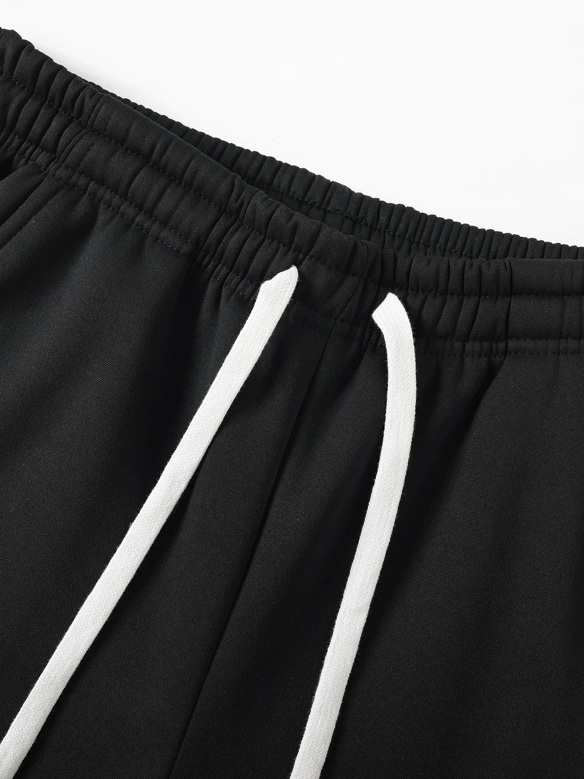 Close-up of black sports pants elastic waistband and white drawstring.