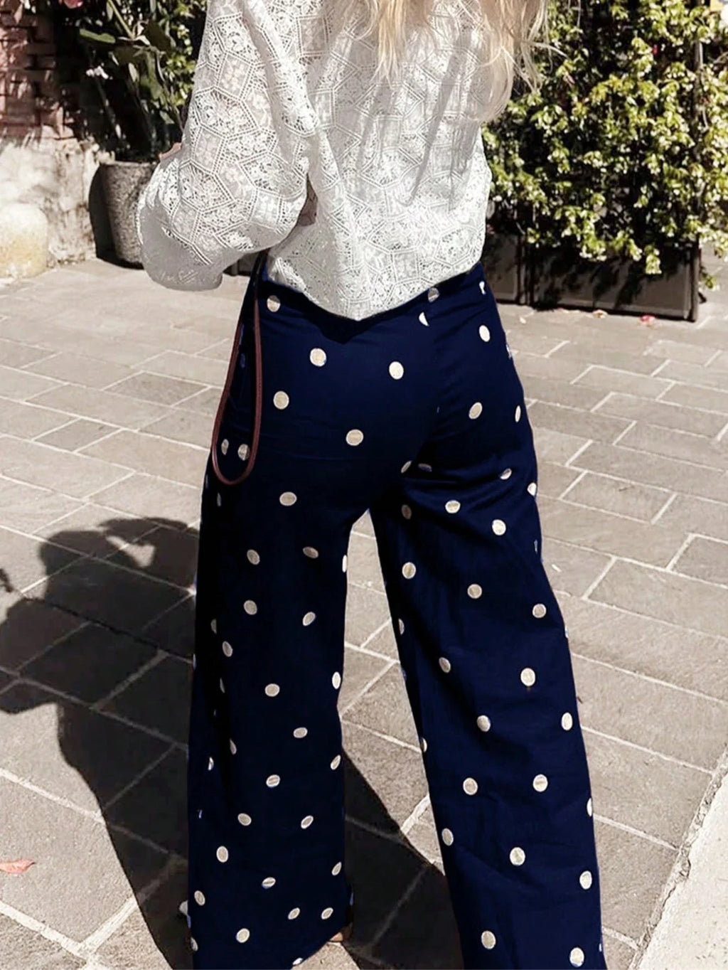 Back view of navy blue polka dot wide-leg trousers