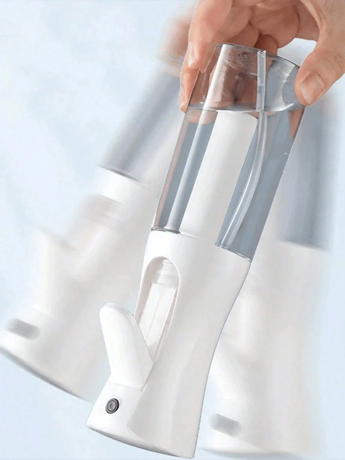 Close-up of a white professional continuous mist spray bottle on a soft background