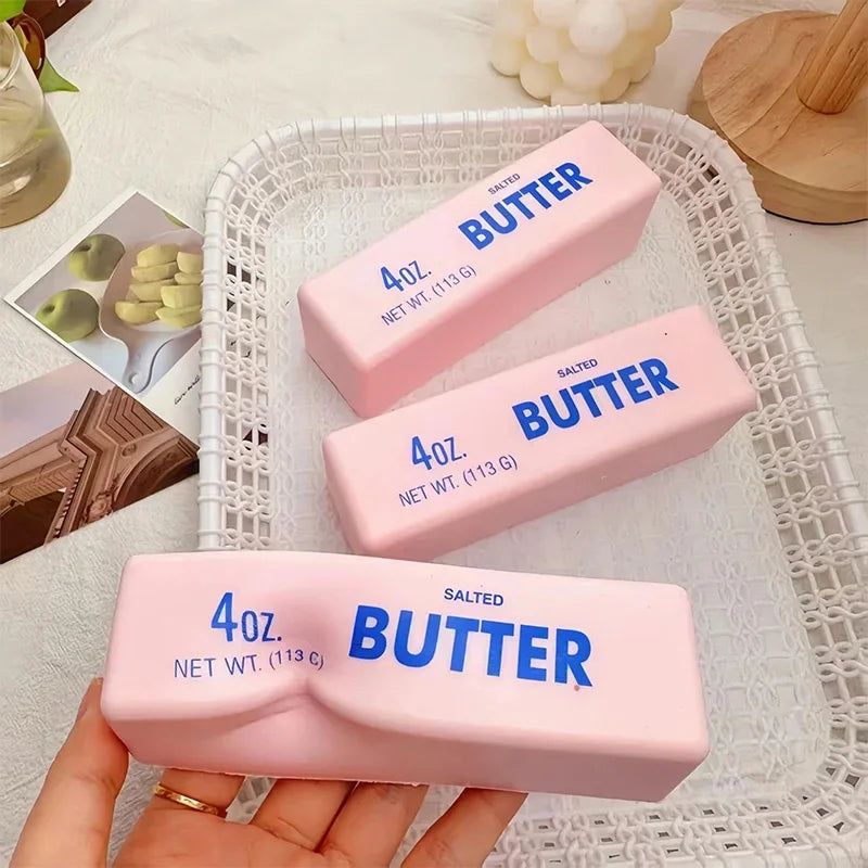 Three pink butter stick squishy toys in a white basket