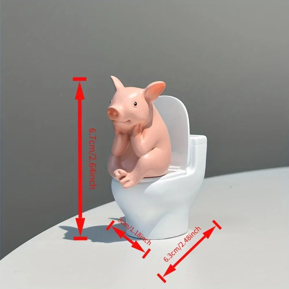 A cute pink pig figurine sitting on a miniature white toilet with red measurement lines indicating its dimensions.