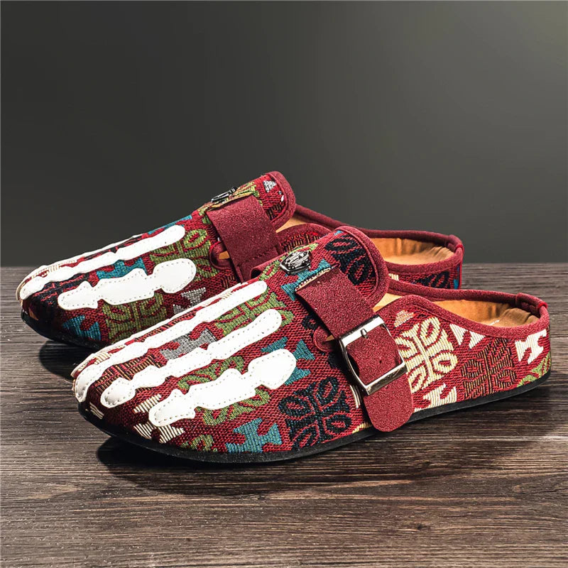 Men's slip-on mule shoes with a red and multicolored patterned fabric and white skeleton hand design, red buckle strap