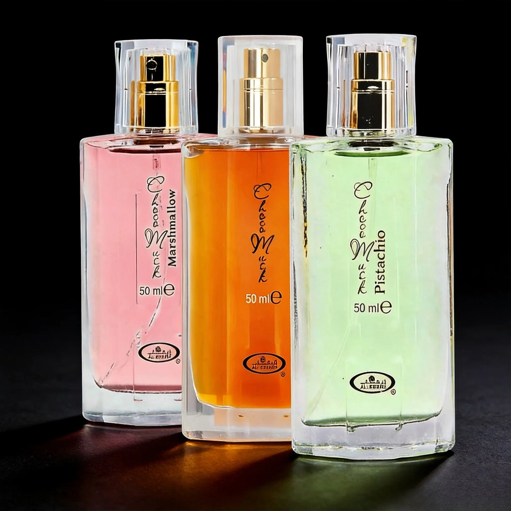 Set of three 50ml glass perfume bottles in pink, orange, and light green, featuring gold spray caps on a black background.