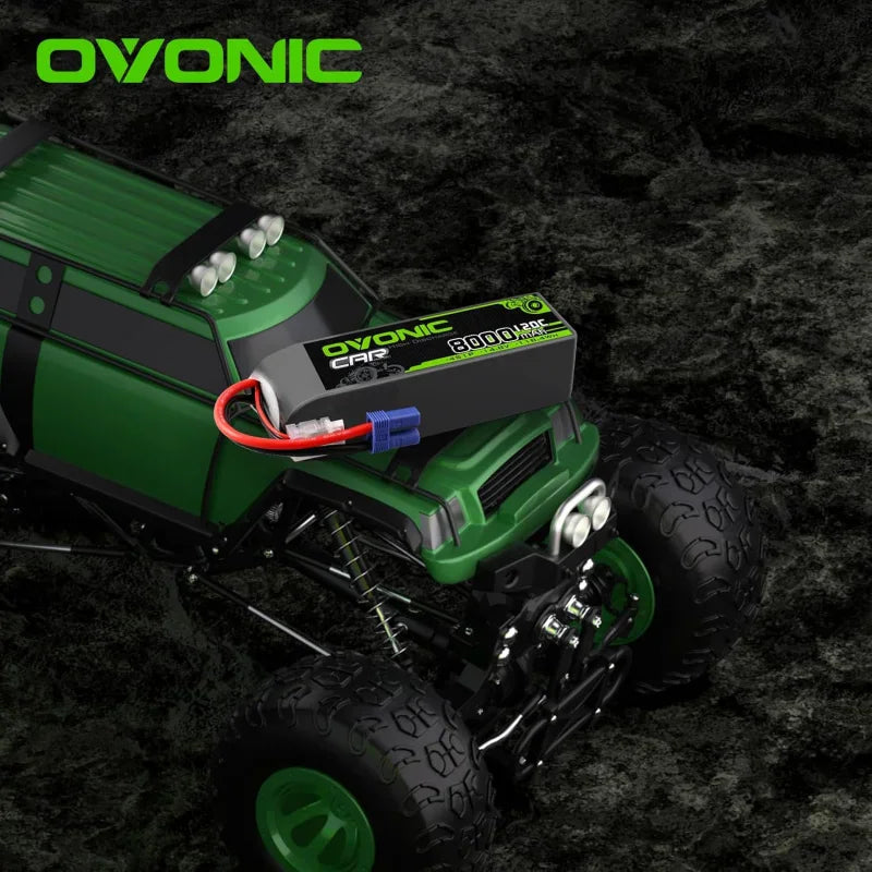 A 14.8V RC car battery displayed on top of a green RC monster truck.