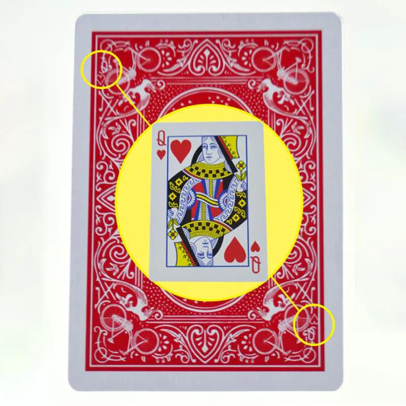 Queen of hearts card shown over the back of a bicycle playing card with markings circled.