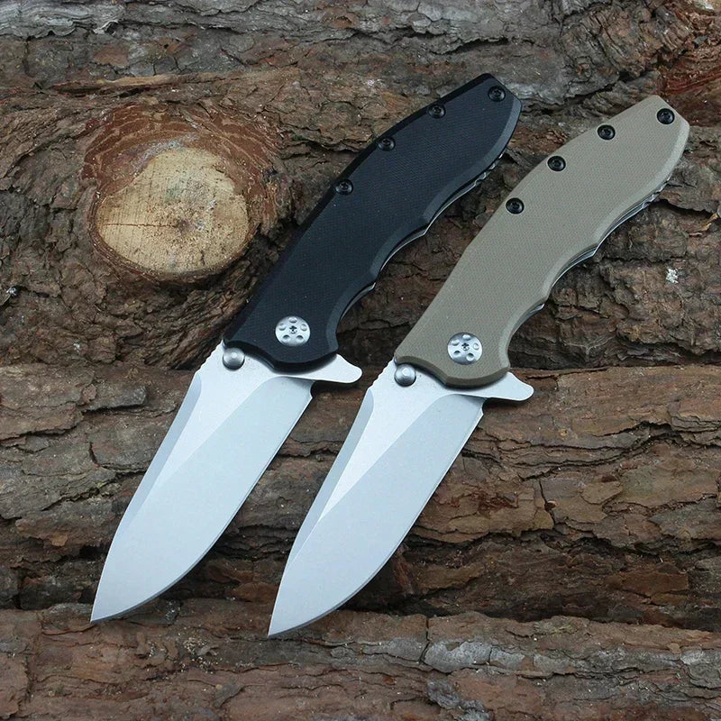 Two folding pocket knives with black and tan handles on a textured wood background