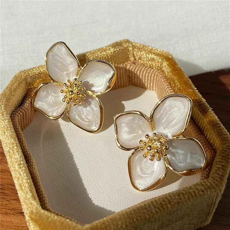 A pair of hibiscus flower stud earrings with a glazed finish and push-back closure.