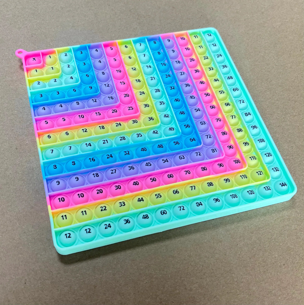 Rainbow colored 12x12 silicone multiplication board game with number pop bubbles