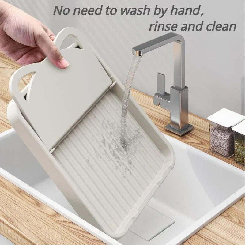 Hand rinsing a beige foldable kitchen utensil rest under a kitchen faucet.