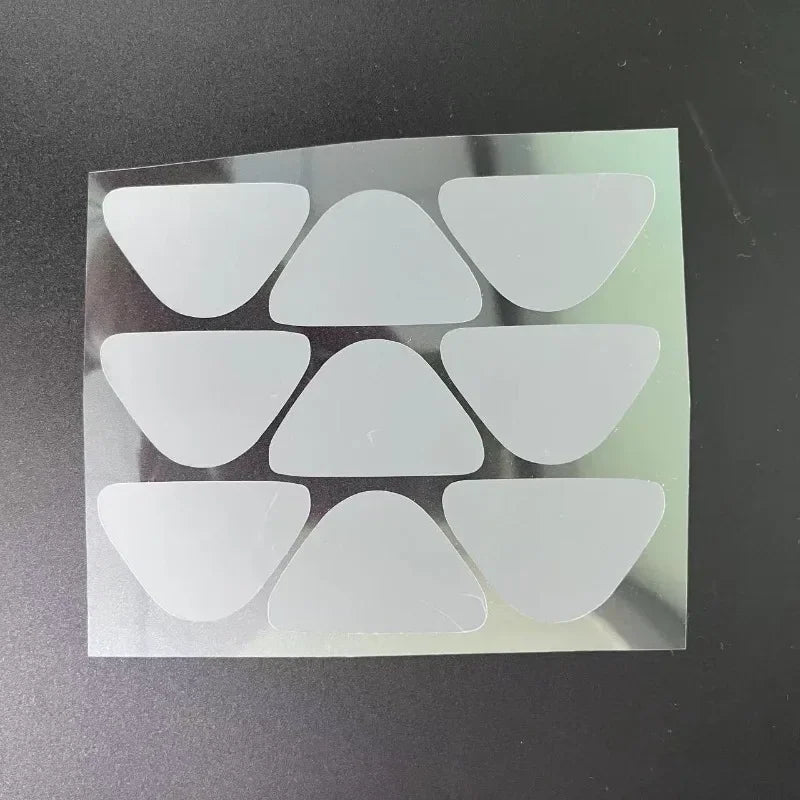 A sheet of nine transparent triangular anti-wrinkle patches on a dark background.