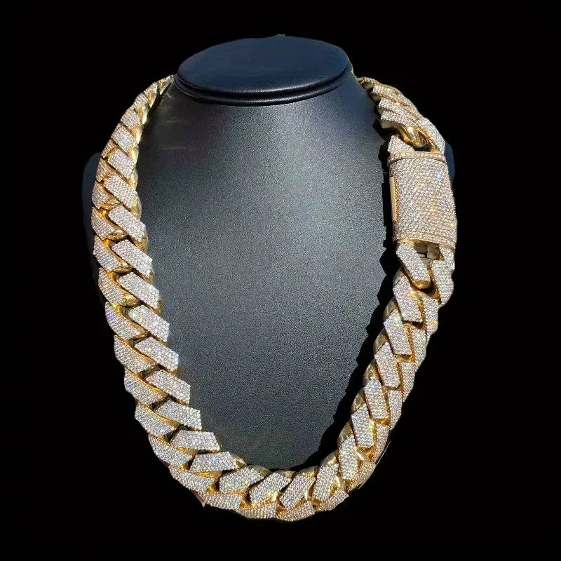 Iced out gold tone Cuban link necklace on a black jewelry display stand