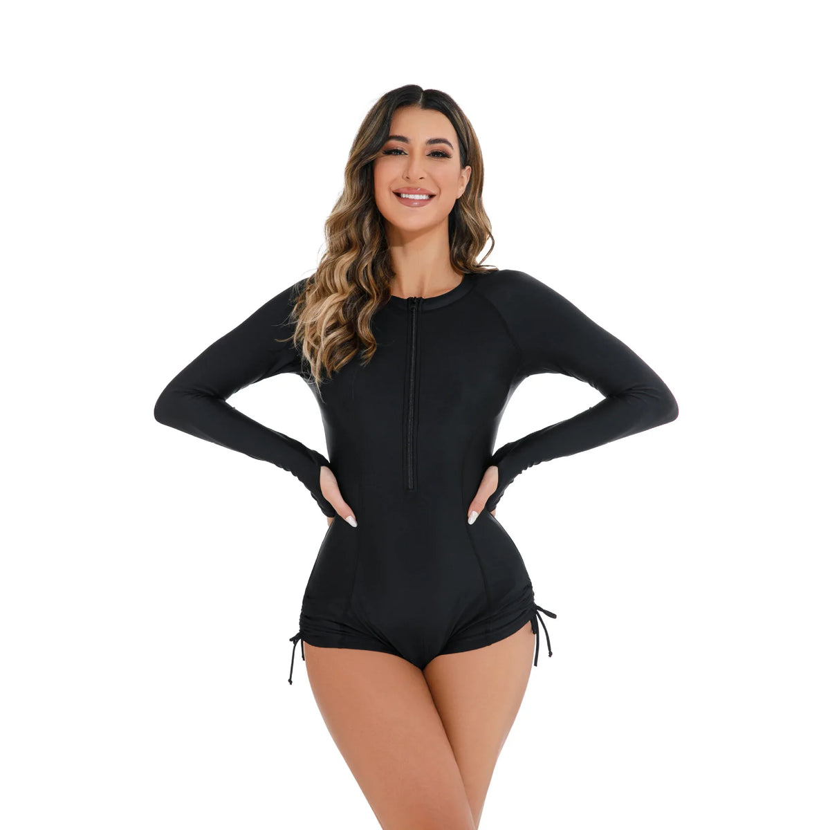 A front view of a woman wearing a black long-sleeve one-piece swimsuit with a front zipper and side drawstrings.