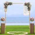 Golden metal square arch stand decorated with flowers for a wedding ceremony on a beach