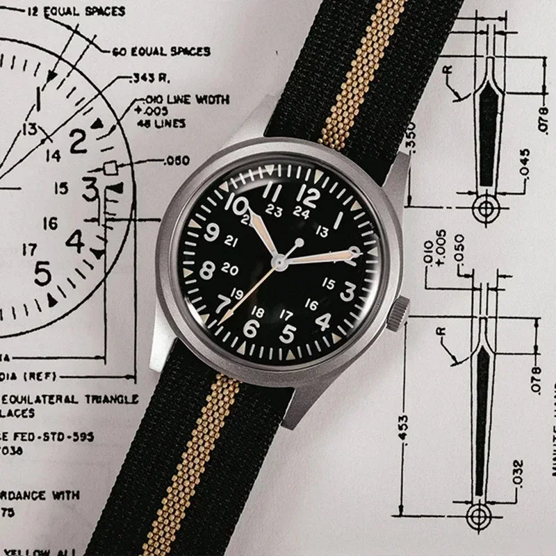 Men's field watch with black dial and striped nylon strap over technical schematic blueprint background