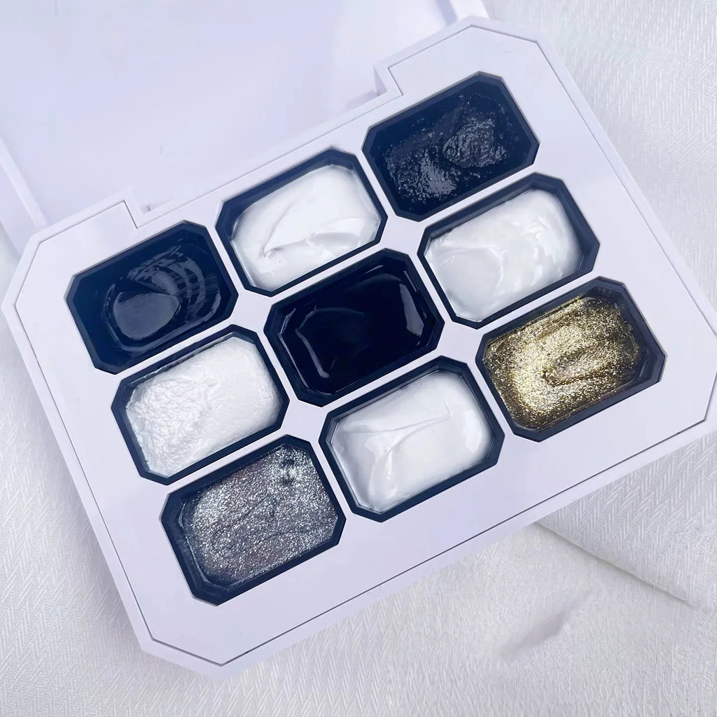 A nine-color solid gel nail polish palette with various black, white, and metallic shades in a white case.