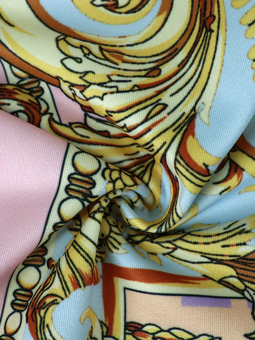 Close up showing the fabric texture and gold, pink, and blue ornate pattern details.