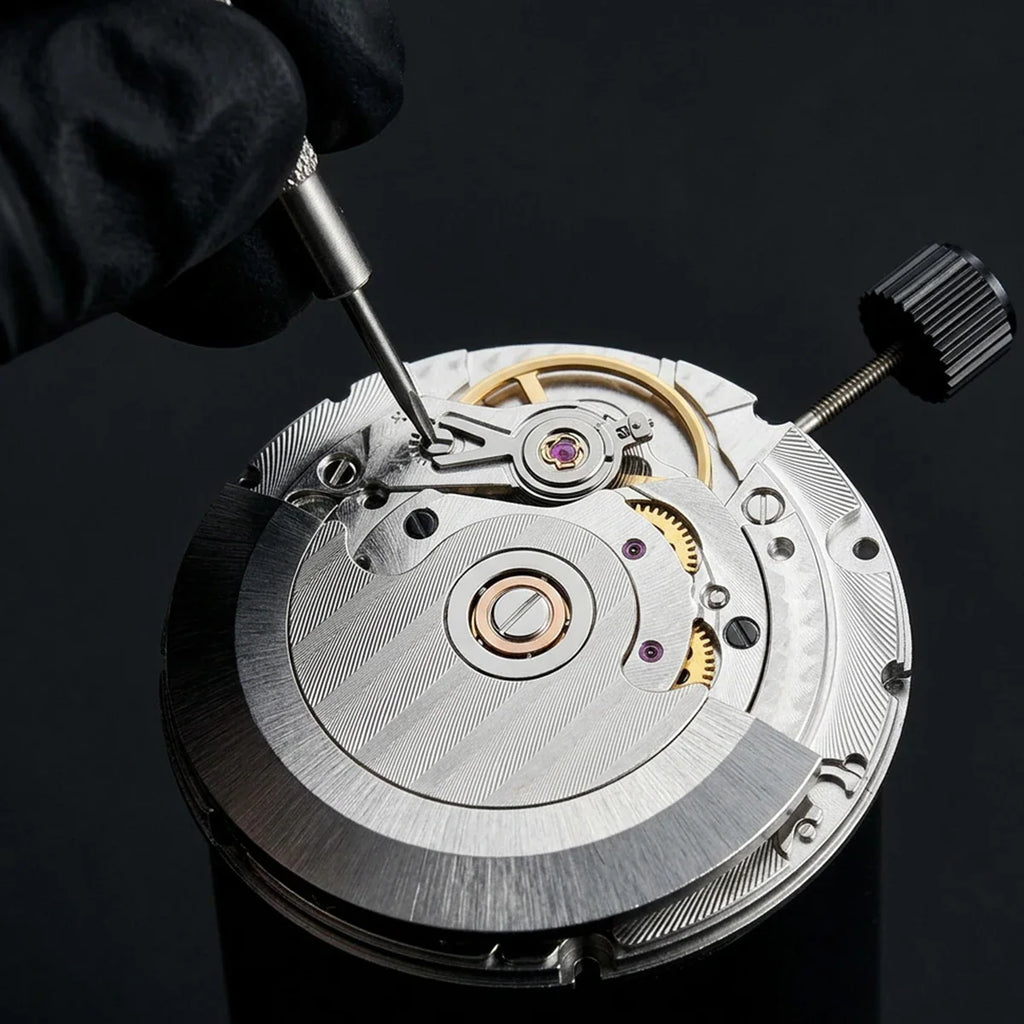 A gloved hand using a professional tool to adjust the balance wheel on a mechanical watch movement.
