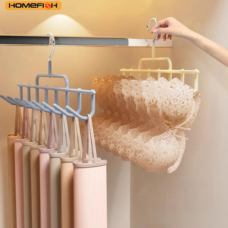 Hand holding a multi-hook clothes hanger organizer with lingerie hanging on it