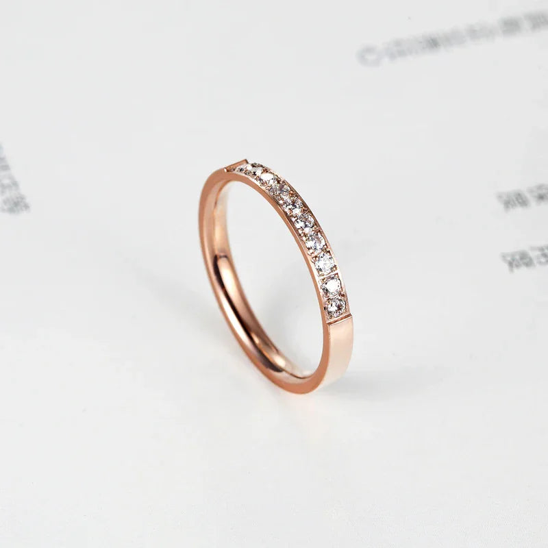 Rose gold tone band ring with a row of inlaid crystals