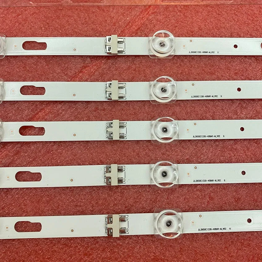 Close-up of television LED strips featuring lenses and connection clips on a red background.