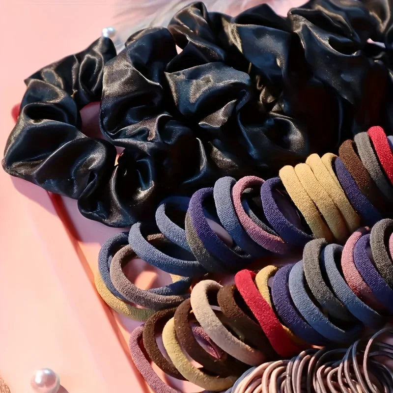 Close-up view of black scrunchies and various colorful elastic hair bands.