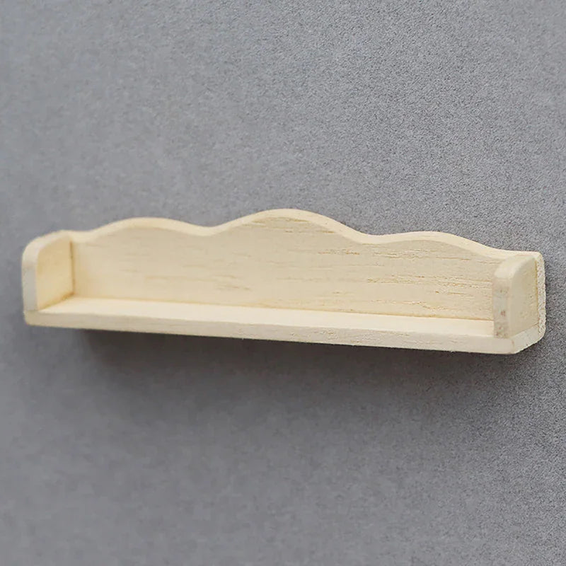 A small, light-colored wooden miniature wall shelf for a dollhouse.