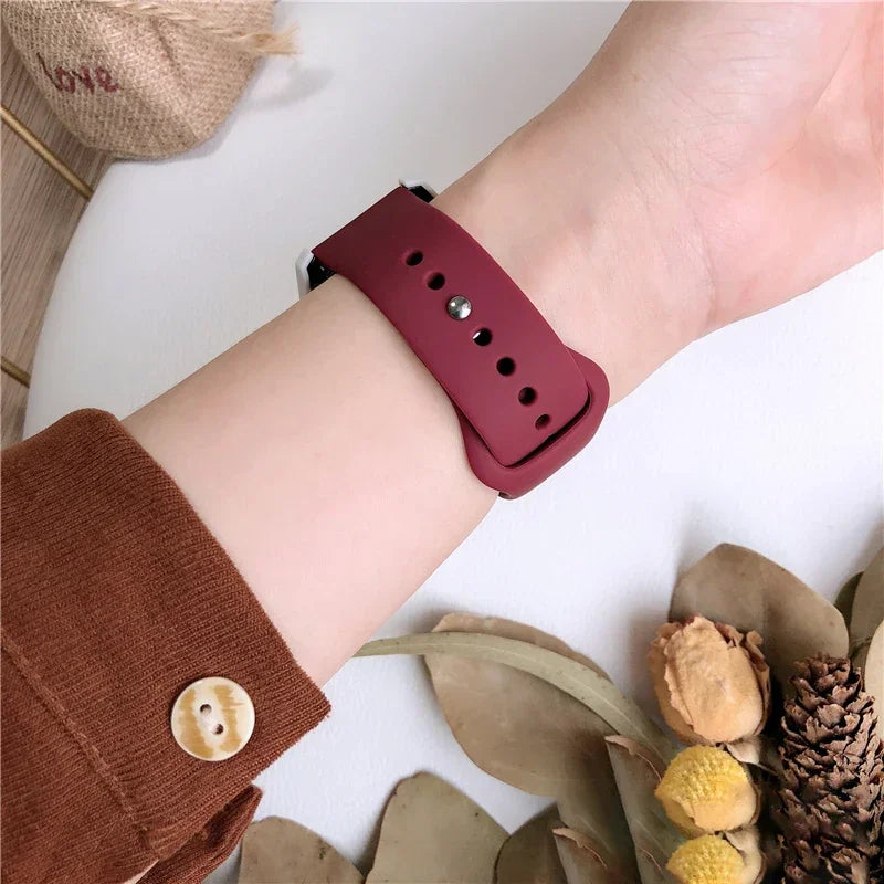 Wrist wearing a dark red silicone watch band.