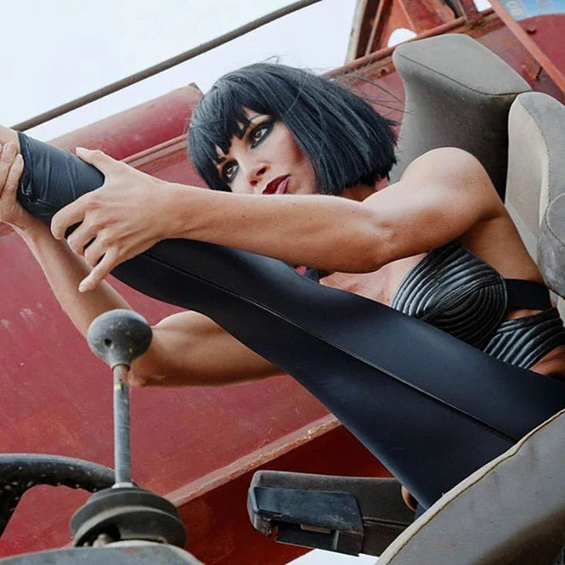 High-waisted black faux leather leggings worn by a person in a car